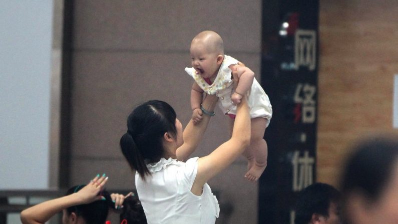 Uma mulher segura seu bebê em Zhengzhou, província de Henan, Centro da China, em 29 de julho de 2014. Reportagens recentes na mídia estatal chinesa têm comentado sobre os grandes lucros, a exploração de mães de aluguel e os abortos seletivos por sexo que acompanham o negócio de barriga de aluguel na China (STR/AFP/Getty Images)