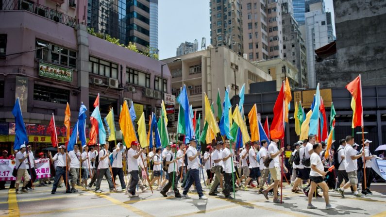 Pessoas carregam faixas enquanto se juntam a uma manifestação organizada por Pequim em Hong Kong, em 17 de agosto de 2014. Milhares provenientes da China continental foram protestar em Hong Kong contra os pedidos de democracia na cidade (Alex Ogle/AFP/Getty Images)