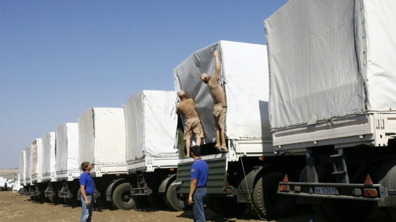 Motoristas russos de caminhões do comboio humanitário russo abrem carga em um campo fora da cidade de Kamensk-Shakhtinsky na região de Rostov, a cerca de 30 km da fronteira russo-ucraniana, Rússia, em 15 de agosto de 2014 (Andrey Kronberg/AFP/Getty Images)