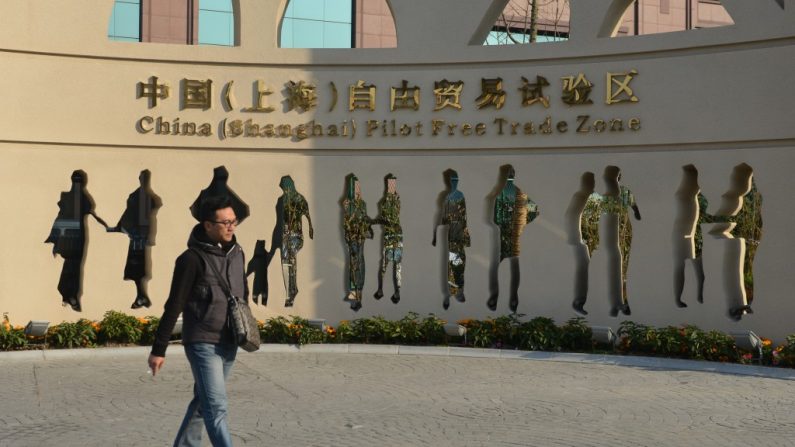Um chinês caminha diante de uma sinalização que promove a Zona Piloto de Livre Comércio de Shanghai, em 28 de novembro de 2013. Autoridades chinesas disseram que hospitais estrangeiros serão permitidos em sete cidades e províncias (Peter Parks/AFP/Getty Images)