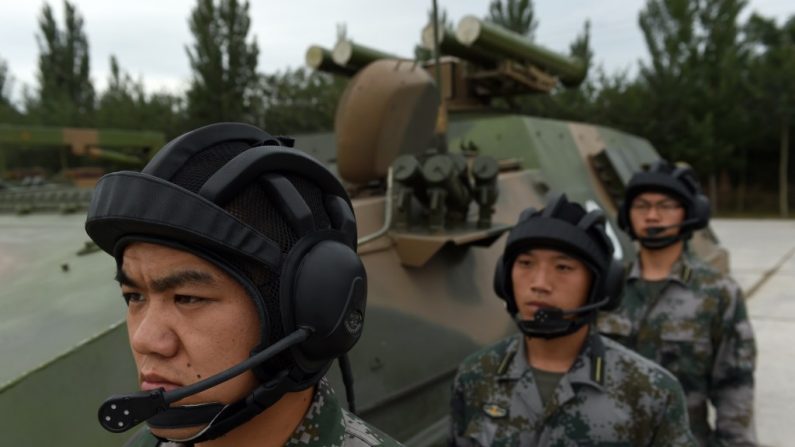 Soldados do Exército da Libertação Popular a postos ao lado de um tanque lança-mísseis T-89 da Academia de Engenharia das Forças Armadas, em Pequim, em 22 de julho. O líder chinês Xi Jinping ordenou um novo foco na guerra cibernética da informação ou ciberguerra (Greg Baker/AFP/Getty Images)