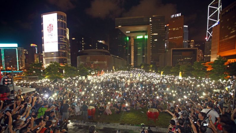 Uma manifestação dos cidadãos de Hong Kong no Parque Tamar, diante da administração central do governo, em 31 de agosto de 2014. Eles protestaram contra a decisão de Pequim de continuar a restringir a democracia em Hong Kong. Manifestantes acenderam seus telefones portáteis como velas para mostrar seu compromisso com a desobediência civil 
(Poon/Epoch Times)