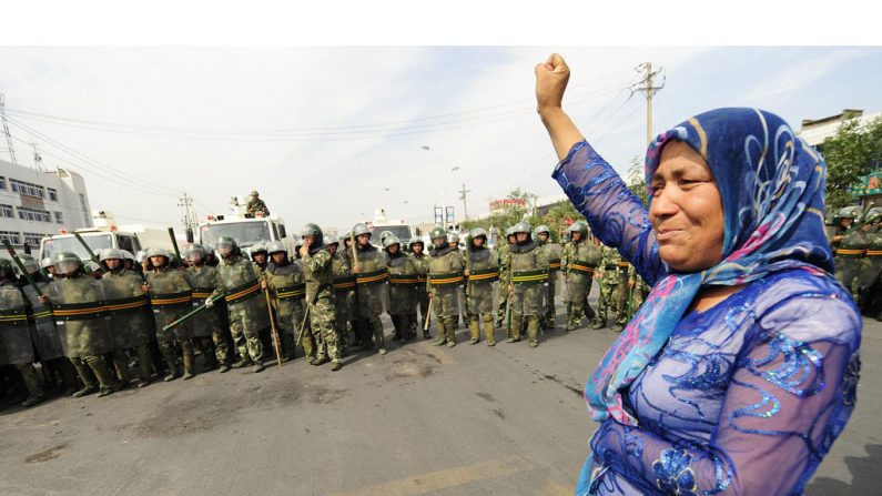 A polícia chinesa observa o protesto de uma muçulmana uigur em Urumqi, capital da província de Xinjiang, extremo Oeste da China, em 7 de julho de 2009. Em 21 de setembro de 2014, explosões coordenadas no condado de Luntai, em Xinjiang, mataram pelo menos duas pessoas (Peter Parks/AFP/Getty Images)