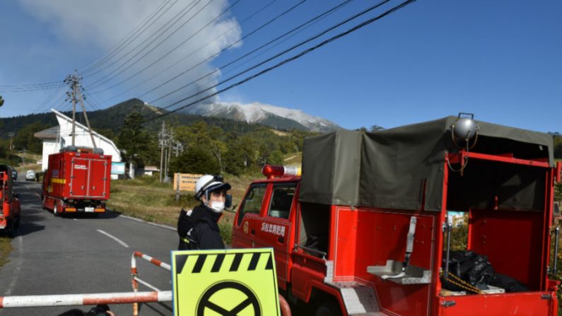 Veículos do corpo de bombeiros percorrem estrada que leva à base do Monte Ontake em Nagano em 28 de setembro de 2014. O vulcão entrou em erupção, disparando cinzas e rochas no ar, deixando oito alpinistas feridos e forçando 150 pessoas a correr para abrigos em cabanas perto do cume (Kazuhiro Nogi/AFP/Getty Images)