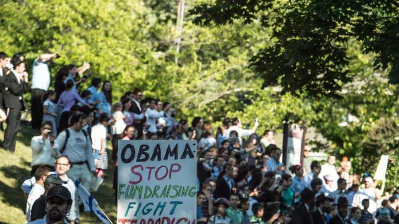 Manifestantes seguram cartazes na chegada do presidente dos EUA, Barack Obama, a Pikesville, Maryland, em 12 de setembro de 2014. A Casa Branca declarou sexta-feira que os Estados Unidos estão em guerra com os radicais do Estado Islâmico. "Os Estados Unidos estão em guerra contra o ISIS da mesma forma que estamos em guerra com a Al-Qaeda e seus afiliados em todo o mundo", disse o porta-voz da Casa Branca, Josh Earnest (Nicholas Kamm/AFP/Getty Images)