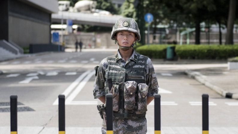 Um soldado do Exército da Libertação Popular (ELP) da China monta guarda na entrada do quartel da guarnição do ELP em Hong Kong em 29 de agosto de 2014. A revista Chengming de Hong Kong afirma que numa reunião de 15 de setembro do alto escalão do Partido Comunista, Zhang Dejiang, um membro do Politburo, esboçou as condições em que a lei marcial seria imposta na cidade rebelde de Hong Kong (Alex Ogle/AFP/Getty Images)