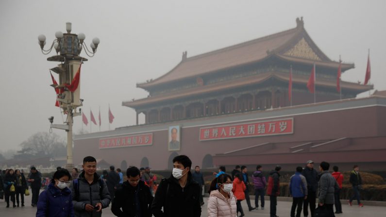 Turistas chineses usam máscaras na Praça da Paz Celestial sob poluição grave em 25 de fevereiro de 2014, em Pequim, China. A alta liderança chinesa irá se reunir para a 4ª Sessão Plenária do Congresso Nacional do 18º Comitê Central do Partido Comunista Chinês, entre 20 e 23 de outubro de 2014 (Lintao Zhang/Getty Images)