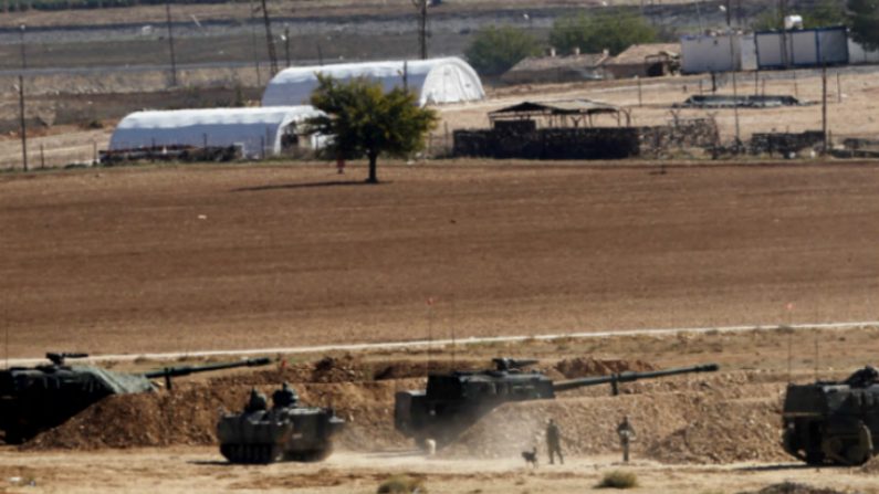 Soldados turcos em seus tanques nos arredores de Suruc, na fronteira Turquia-Síria, com vista para Kobani, Síria, ao fundo, durante os confrontos entre curdos sírios e os militantes do grupo Estado Islâmico, em 22 de outubro de 2014. A cidade síria de Kobani foi mais uma vez atingida por uma batalha feroz entre o Estado islâmico e forças curdas da Síria. (Gokhan Sahin/Getty Images)