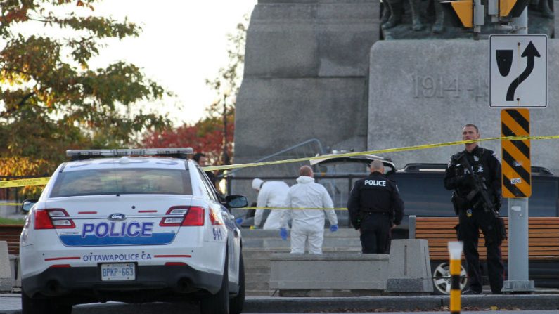 Policiais forenses trabalham perto do memorial de guerra em Ottawa, Canadá, na quarta-feira, 22 de outubro de 2014. Um homem armado abriu fogo no National War Memorial matando um soldado antes de entrar na sede do parlamento, disparando vários tiros no edifício (Lars Hagberg/AFP/Getty Images)