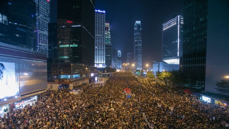 Dezenas de milhares de pessoas se reúnem na avenida central Connaught, em 4 de outubro, próximo ao prédio das forças armadas do Exército da Libertação Popular, em Hong Kong. Os manifestantes exigem a renúncia do chefe-executivo Leung Chun-ying (Benjamin Chasteen/Epoch Times)