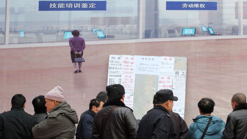 Trabalhadores migrantes leem um quadro de avisos de trabalho em Qingdao, província de Shandong, Leste da China, em 17 de fevereiro de 2014 (STR/AFP/Getty Images)