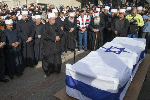 Amigos, parentes e dignitários religiosos choram perto do caixão do policial israelense Zidan Saief, 30, um membro da minoria drusa de Israel, durante seu funeral em sua aldeia natal norte do Yanuh-Jat, em 19 de novembro de 2014. Saief morreu depois de sofrer ferimentos graves, elevando o número de mortos para cinco, quando dois palestinos armados com uma arma e um machado irromperam na sinagoga e mataram quatro israelenses, antes de ser morto a tiros em mais um sangrento ataque contra Jerusalém nos últimos anos (JACK GUEZ/AFP/Getty Images)