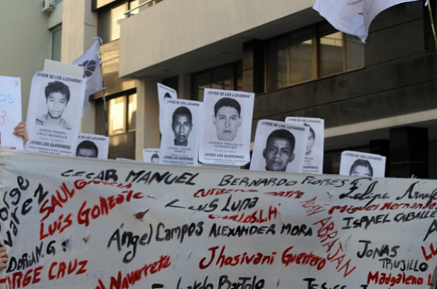 Ativistas de várias organizações sociais seguram cartazes durante uma marcha à embaixada mexicana em Montevidéu, exigindo justiça no caso dos 43 alunos que desapareceram de Ayotzinapa, no estado de Guerrero desde o dia 26 de setembro em Montevidéu, em 17 de novembro de 2014 (MIGUEL ROJO/AFP/Getty Images)