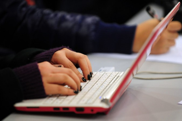 Uma mulher digita em seu laptop em Pequim. Vazamentos de e-mail mostram que o regime chinês emprega pelo menos 500 mil comentaristas pagos, seu "Exército dos Cinquenta Centavos" (Frederic J. Brown/AFP/Getty Images)