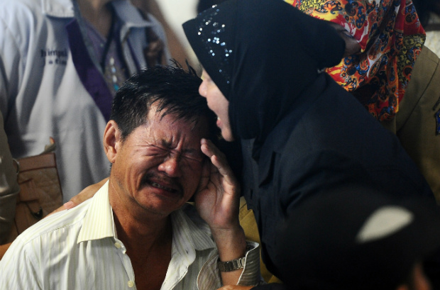 Parentes de passageiros do voo QZ8501 da AirAsia reagem à notícia da localização de destroços do avião e corpos dos passageiros, encontrados em 30 de dezembro de 2014 em Surabaia, na Indonésia (Robertus Pudyanto/Getty Images)