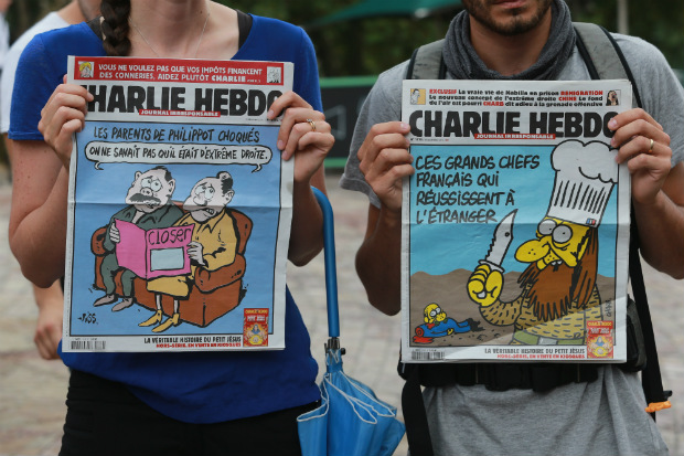 Pessoas seguram cartazes durante uma vigília para as vítimas do massacre em Paris na Federation Square em 8 de janeiro de 2015, em Melbourne, Austrália. Os membros da comunidade francesa reuniram-se na Federation Square para uma vigília após um ataque de homens armados e mascarados na sede da revista satírica Charlie Hebdo, que matou 12 pessoas em Paris (Wayne Taylor/Getty Images)