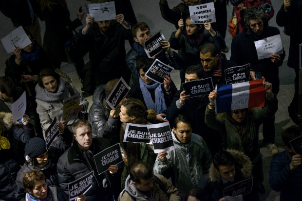 Pessoas seguram cartazes com as palavras "Je Suis Charlie" (Eu Sou Charlie) do lado de fora do Museu da Mídia em Washington, DC, em 07 de janeiro de 2015. Elas se reuniram no Newseum em solidariedade às vítimas do tiroteio que aconteceu no escritório do jornal satírico Charlie Hebdo em Paris, que tirou a vida de 12 pessoas (BRENDAN SMIALOWSKI/AFP/Getty Images)