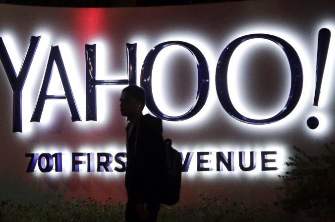 Uma pessoa anda na frente de um luminoso Yahoo na sede da empresa em Sunnyvale, Califórnia, em 5 de novembro de 2014. (AP Photo / Marcio Jose Sanchez)