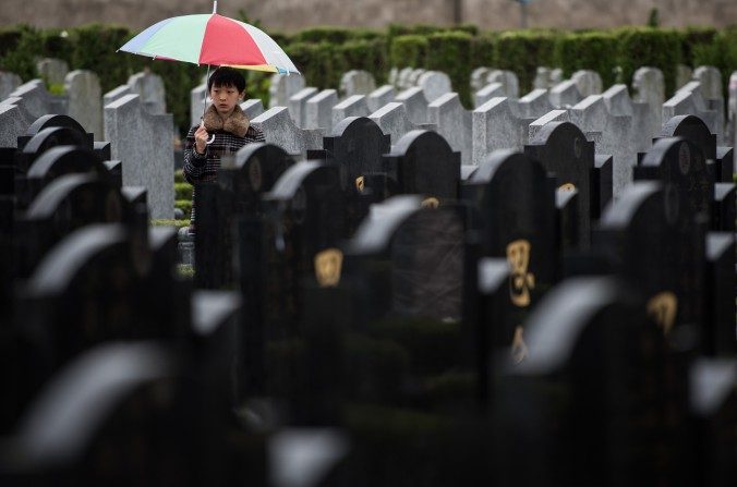 Menino em pé entre sepulturas durante o festival anual “Qingming”, no cemitério público de Shanghai (Johannes Eisele/AFP/Getty Images)