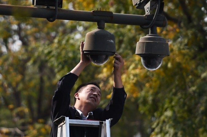 Um trabalhador ajusta câmaras de segurança em uma das extremidades da praça de Tiananmen em Pequim, em setembro de 2014 (GREG BAKER/AFP/Getty Images)