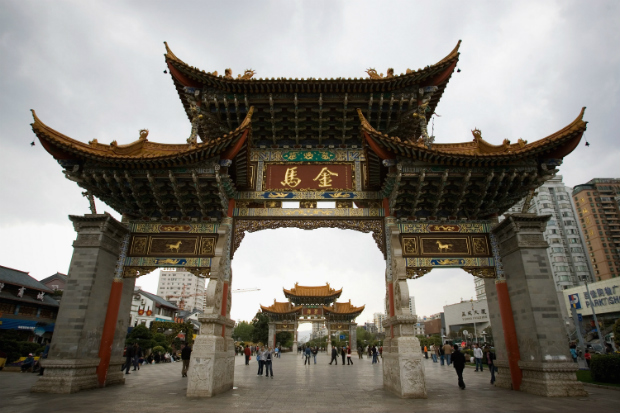 Pessoas caminham sob o Golden Horse Memorial Archway em 23 de Março de 2008 em Kunming, província de Yunnan (Feng Li/Getty Images)