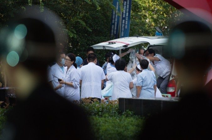 Médicos e enfermeiros recebem num hospital da China uma vítima de explosão em uma fabrica (Johannes EiseleE/AFP/Getty Images)