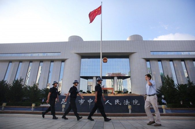 Patrulha da polícia no portão do Tribunal de Intermediação da Corte de Kunming, em Kunming, sudoeste da província de Yunnan, na China, em 12 de setembro de 2014 (STR / AFP / Getty Images)