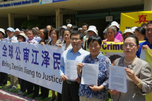 Sr. Zhang Jin, sra. Li Shuying e sra. Shi Zhenghua (da esq. para a dir.) exibem cópias das queixas criminais apresentadas contra Jiang Zemin (Minghui.org)