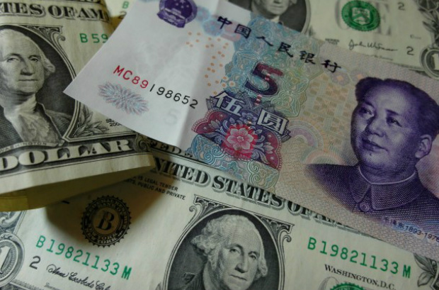 Notas de yuan e dólares norte-americanos são vistas em uma tabela em Yichang, província de Hubei, na China central, em 14 de agosto (STR/AFP/Getty Images)