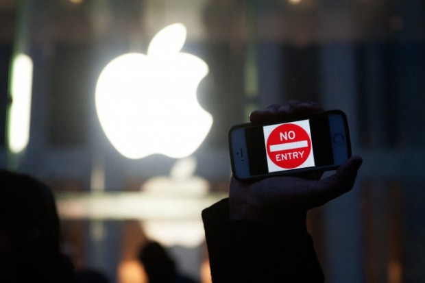 Um manifestante mostra um iPhone que lê "não entre" fora da loja da Apple na 5th Avenue , em Nova York, no dia 23 de fevereiro. Enquanto a Apple diz apoiar a privacidade do usuário nos Estados Unidos, ela tem cooperado estreitamente com as autoridades na China  ( Bryan Thomas / Getty Images )