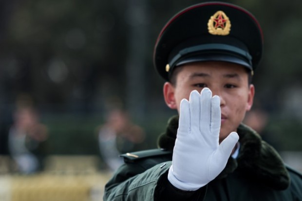 Um guarda faz gestos fora do Grande Salão do Povo, em Pequim, durante o segundo dia do Congresso Nacional do Povo, em 6 de março. O regime chinês anunciou recentemente sua Associação de Ciber Segurança da China, que será a alavanca para o seu projeto de governar a internet global  (Johannes Eisele / AFP / Getty Images)