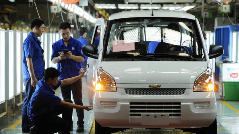 Funcionários chineses trabalham na linha de produção de uma fábrica de carros em Qingdao, China, em 15 de julho de 2015. (STR/AFP/Getty Images)