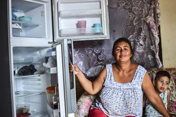 Uma mulher mostra seu refrigerador vazio em sua casa em Caracas, Venezuela, em 2 de junho. Muitos venezuelanos são incapazes de comprar comida suficiente (RONALDO SCHEMIDT / AFP / Getty Images)