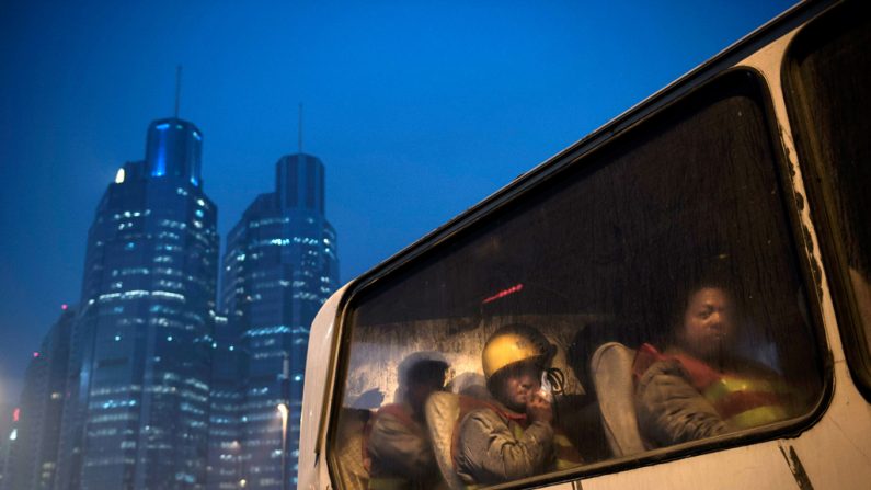 Trabalhadores migrantes chineses pegam um ônibus após seu turno num canteiro de obras em Pequim em 9 de dezembro de 2014. (Kevin Frayer/Getty Images)