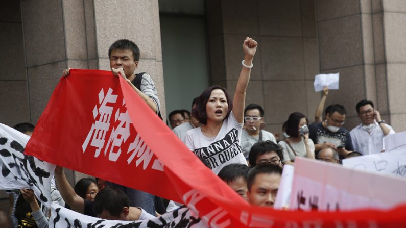 Manifestantes chineses protestam diante de um hotel onde as autoridades realizam uma conferência de imprensa em Tianjin, após uma grande explosão química, em 17 de agosto de 2015. (STR/AFP/Getty Images)