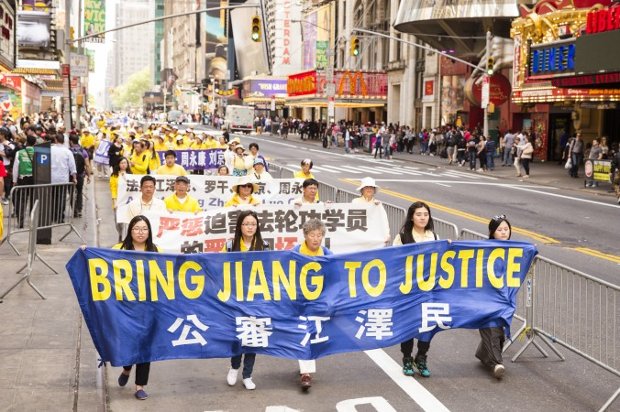 Praticantes do Falun Gong carregam uma faixa citando Jiang Zemin, o líder anterior do partido chinês que é diretamente responsável pela perseguição ao Falun Gong desde julho de 1999 (Edward Dye/Epoch Times)