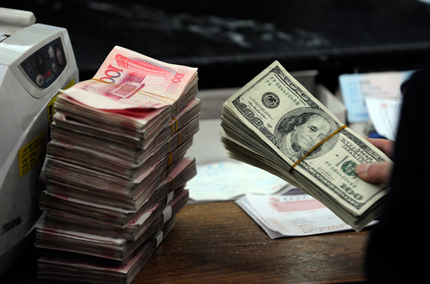 Notas de dólar dos EUA ao lado de notas de yuan chinês num banco da cidade de Hefei, província de Anhui, Leste da China, em 9 de março de 2010 (STR/AFP/Getty Images)