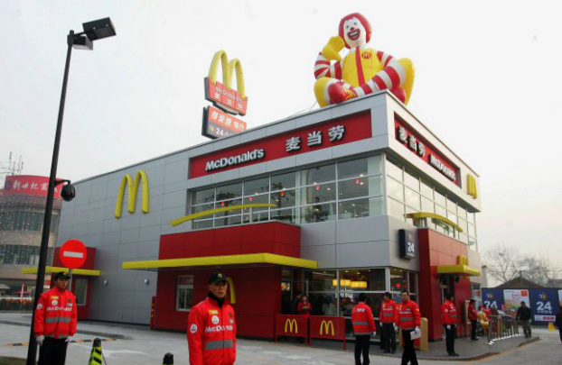 Empregados chineses aguardam primeiros clientes na abertura de uma lanchonete do McDonald's construída ao lado de um posto de abastecimento de gasolina em Pequim, em 19 de janeiro de 2007. Depois de anunciar que mudaria seu nome na China, McDonald’s foi ridicularizado nas redes sociais chinesas (STR/AFP/Getty Images)