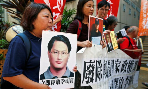 Manifestantes pró-democracia carregam fotos do ativista taiwanês Lee Ming-che, em protesto em Hong Kong – 11 de setembro (Reuters/Bobby Yip)