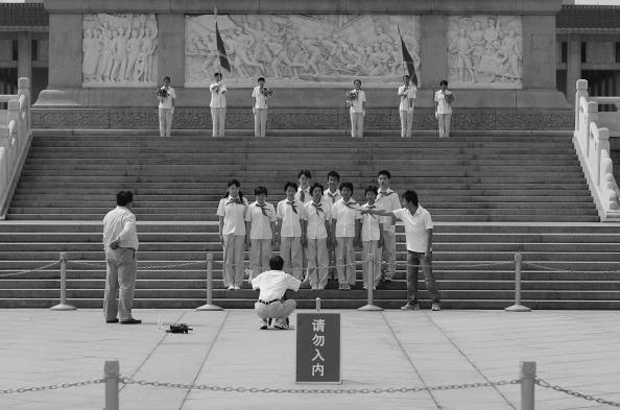 Membros da Liga da Juventude Comunista da China posam para foto diante do Monumento dos Heróis na Praça da Paz Celestial em Pequi, China, em 4 de junho de 2007 (Guang Niu/Getty Images)