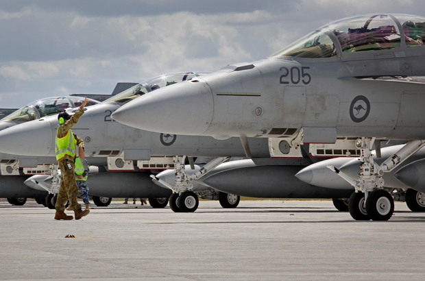 Pessoal de terra orienta um avião de combate F/A-18F Super Hornets da Força Aérea Real Australiana que se preparar para voar a partir de uma base em Amberley, na Austrália, em 21 de setembro de 2014 (cabo Ben Dempster/Força Aérea Real Australiana via Getty Images)