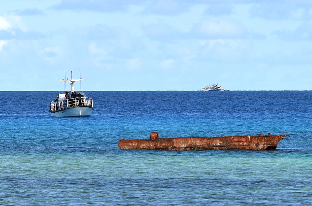 Uma embarcação de pesquisa (esq.) e um barco filipino (dir. no fundo) ancorado perto das Ilhas Thitu no Mar do Sul da China em 21 de abril de 2017 (Ted Aljibe/AFP/Getty Images)