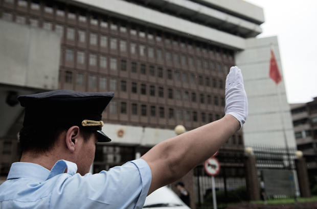 Um policial chinês gesticula em frente do Tribunal Intermediário de Xangai em 8 de agosto de 2014 (Johannes Eisele/AFP/Getty Images)