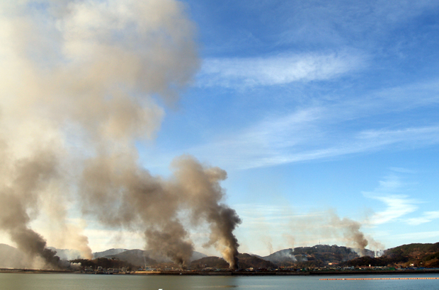 Fumaça sobe nos céus da Ilha Yeonpyeong no Mar Amarelo em 23 de novembro de 2010, após um ataque de artilharia e mísseis da Coreia do Norte (STR/AFP/Getty Images)