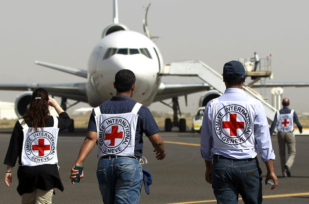 Membros do Comitê Internacional da Cruz Vermelha caminham em direção a um avião no aeroporto internacional de Sanaa, no Iêmen, em 11 de abril de 2015 (Mohammed Huwais/AFP/Getty Images)