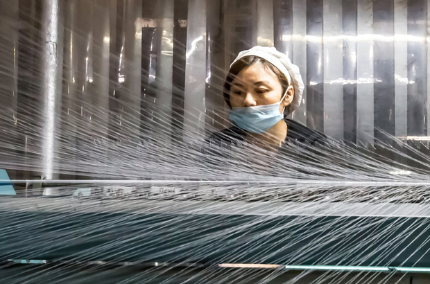 Uma chinesa trabalha numa fábrica têxtil em Nantong, na província de Jiangsu, Leste da China em 10 de dezembro de 2016 (STR/AFP/Getty Images)