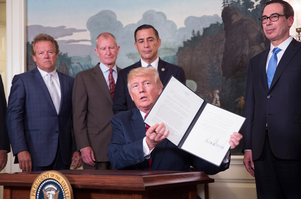 O presidente norte-americano Donald Trump assina um memorando para investigar as práticas de comércio da China, na Casa Branca em Washington, D.C., em 14 de agosto de 2017 (Chris Kleponis/Getty Images)