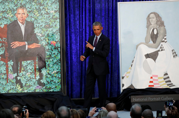 O ex-presidente norte-americano Barack Obama entre seu retrato e o da ex-primeira-dama Michelle Obama durante uma cerimônia de apresentação das pinturas na Galeria de Retrato Nacional do Smithsonian, em Washington, D.C., em 12 de fevereiro de 2018 (Jim Bourg/Reuters)