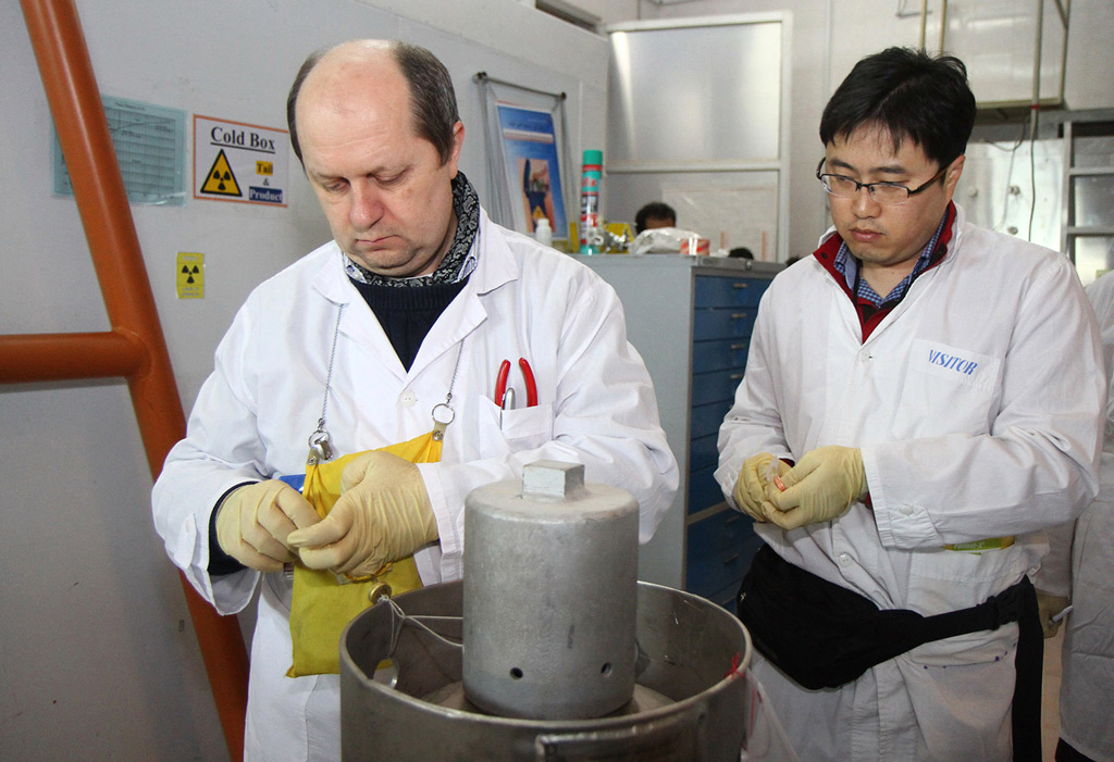 Inspetores da Agência Internacional de Energia Atômica (AIEA) não identificados desconectam as conexões entre equipamentos para produção de urânio altamente enriquecido na usina nuclear de Natanz (Kazem Ghane/AFP/Getty Images)