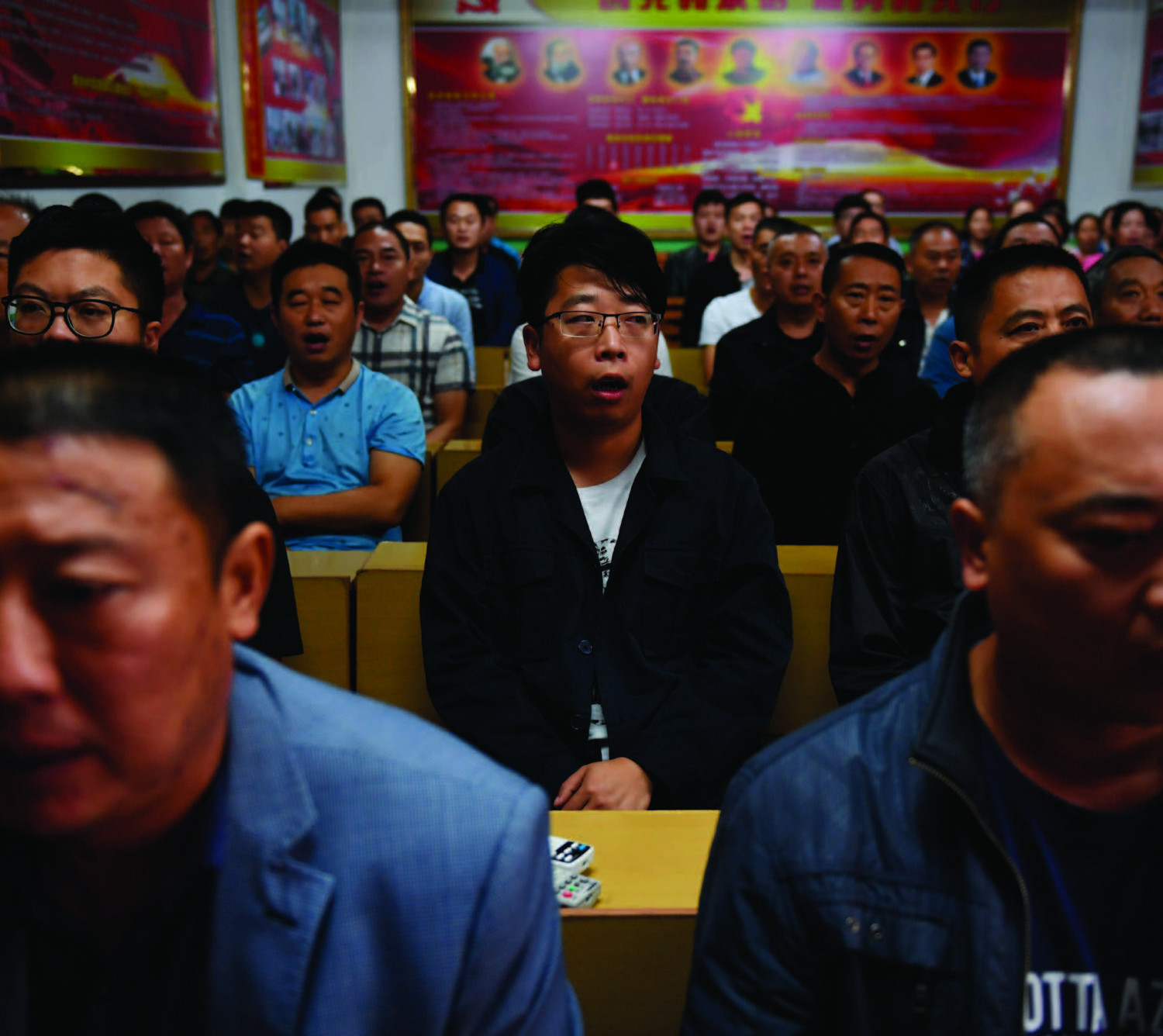 Gerentes de fábricas cantam canções vermelhas comunistas no início do seu dia de trabalho no vilarejo de Nanjie, na região central da província de Henan, em 27 de setembro de 2017 (Greg Baker/AFP/Getty Images)